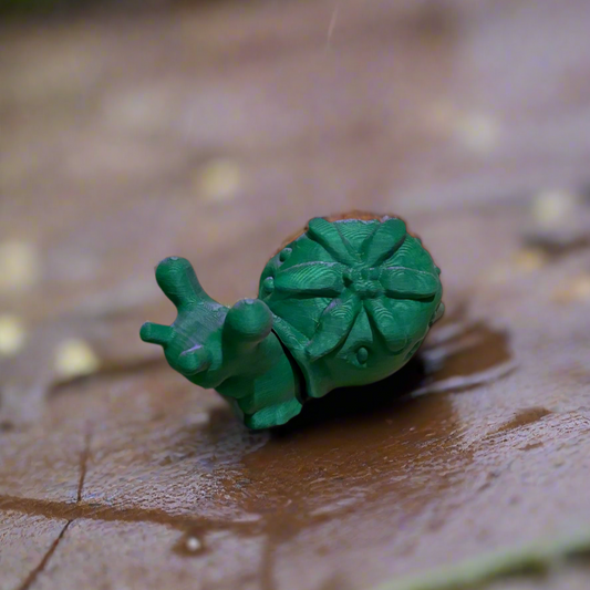 Green strawberry snail 3D print with detailed shell design.