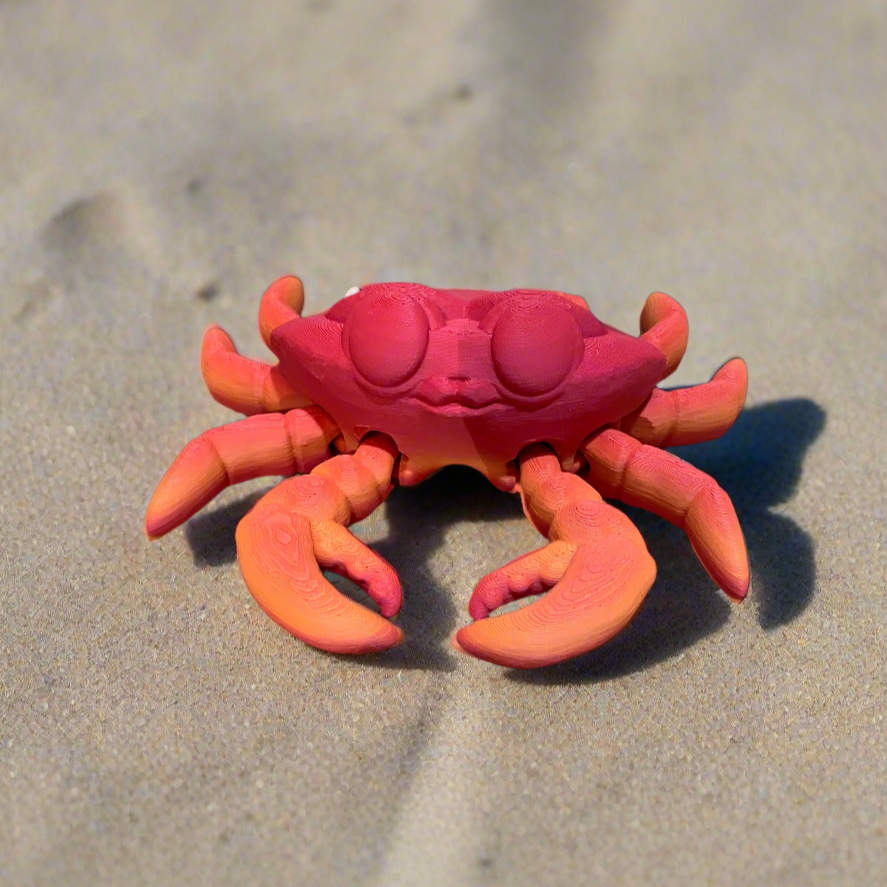 Tiny 3D printed crab with a vibrant pink and orange color design.
