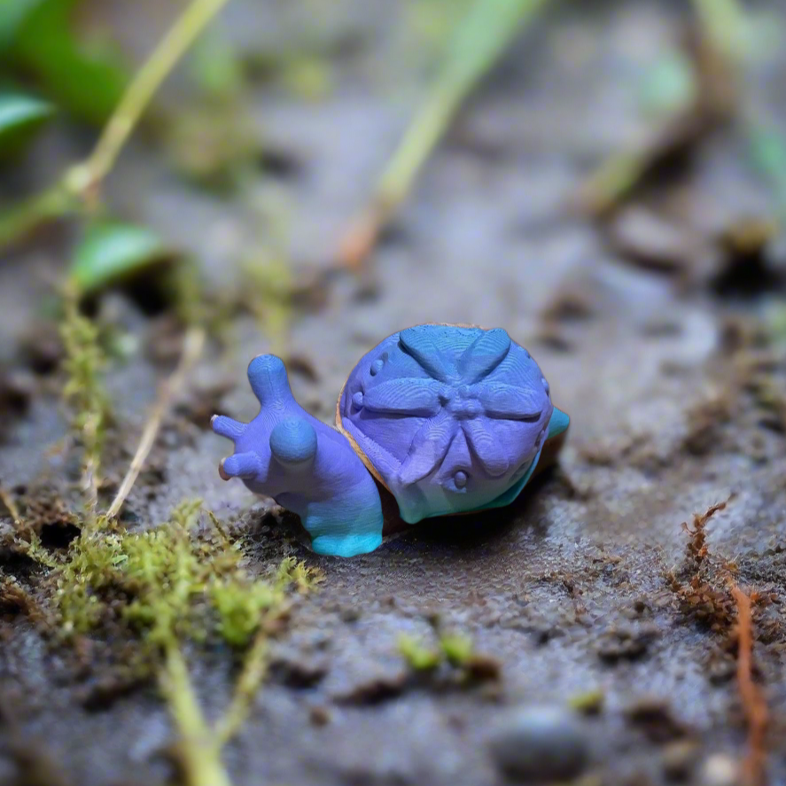 Tiny snail 3D print in purple and blue with detailed shell design.