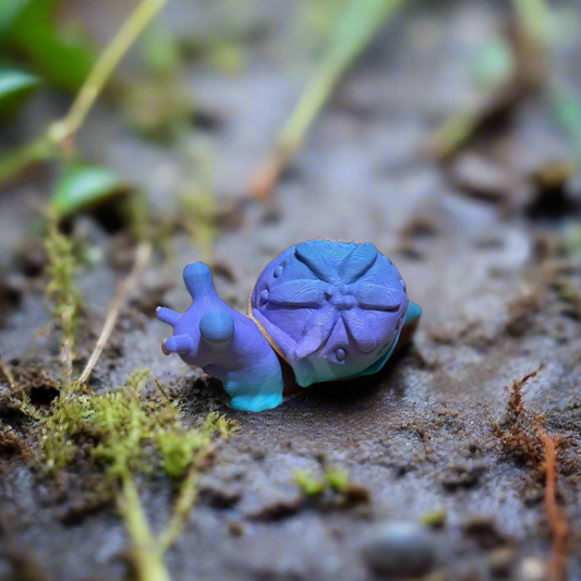 Tiny snail 3D print in purple and blue with detailed shell design.
